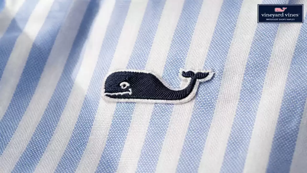 Close-up of a blue and white cotton shirt with an embroidered whale logo.