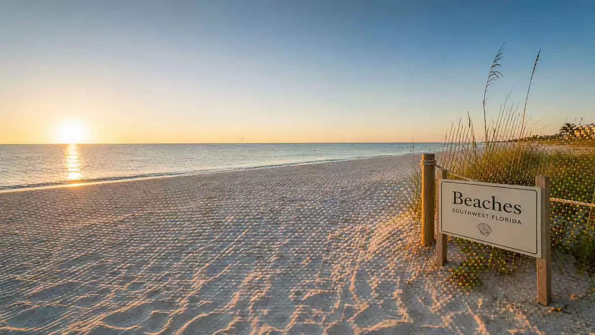 A tranquil beach in Southwest Florida at sunset, with a sign describing the region's beaches.