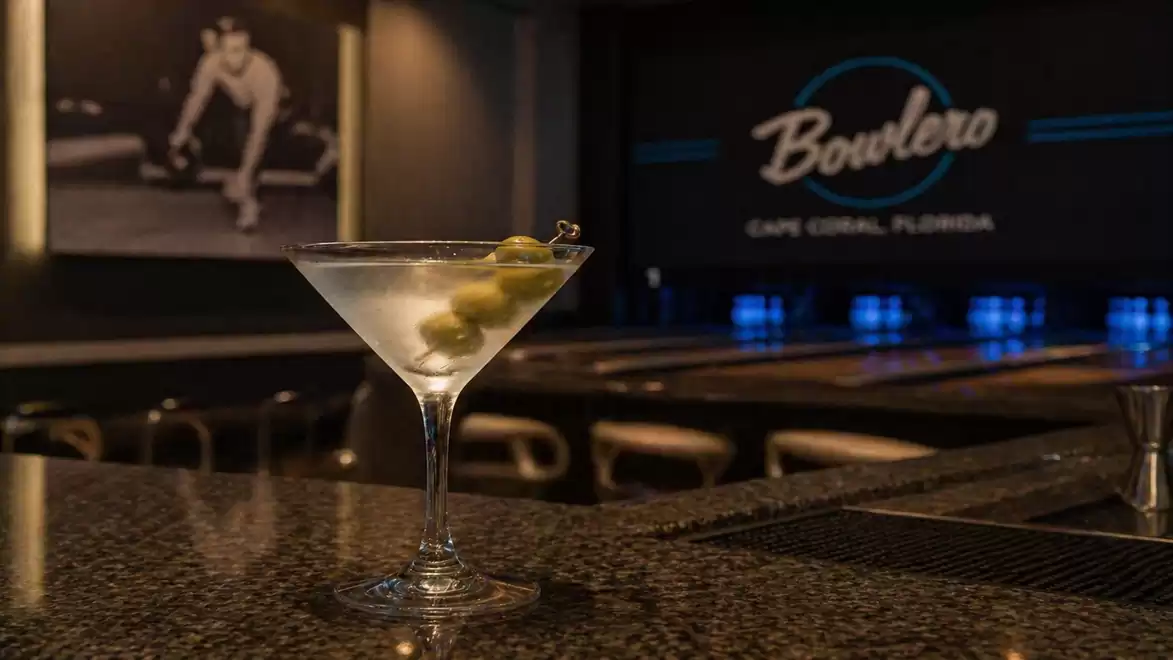 A martini cocktail on the bar in a bowling lounge with a retro-modern atmosphere.