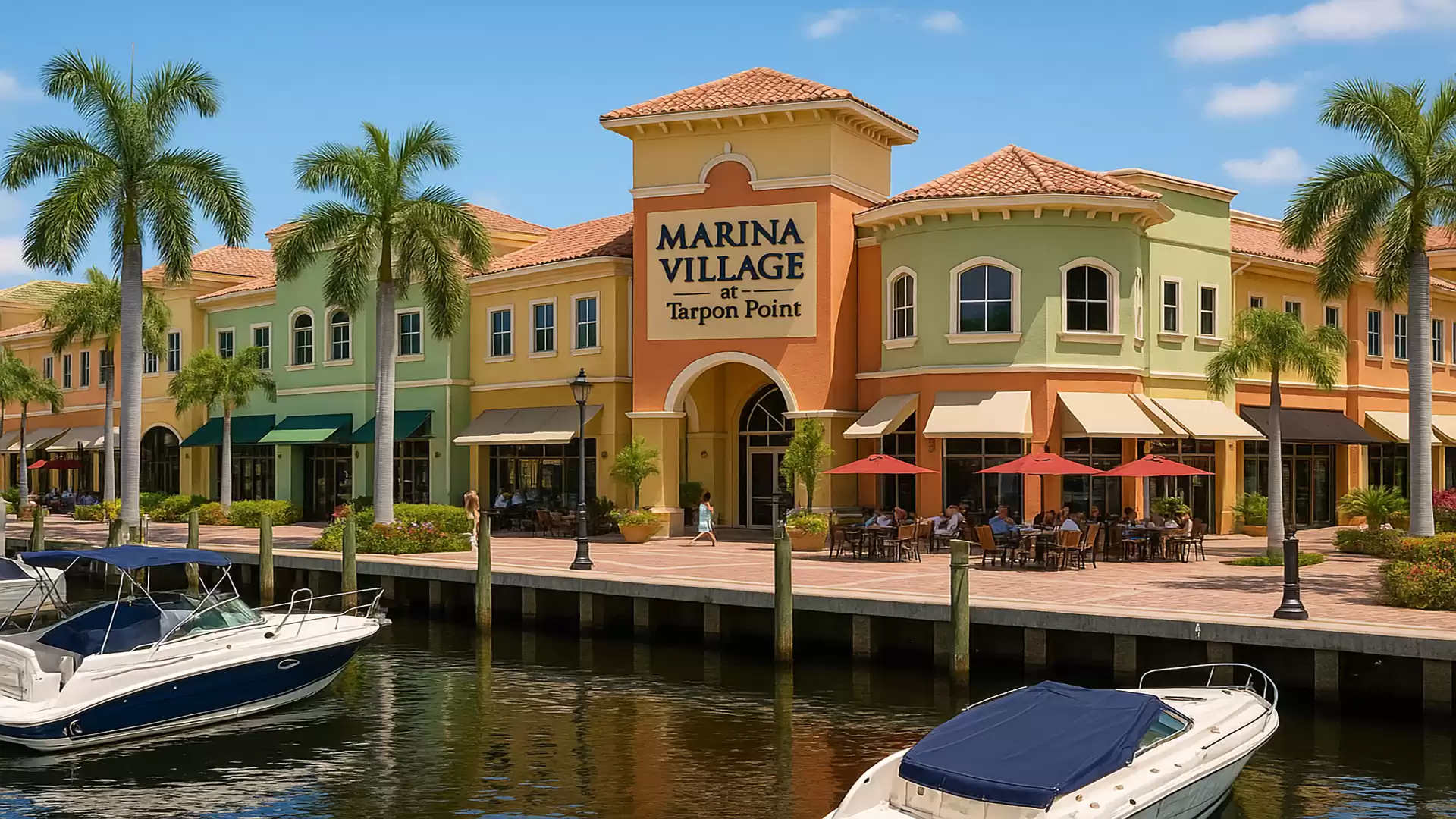 Colorful commercial buildings and boats on the water in front of Marina Village at Tarpon Point.