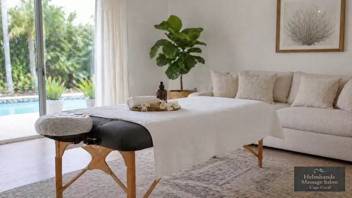 A massage room with a comfortable bed in a bright, stylish room overlooking the garden.