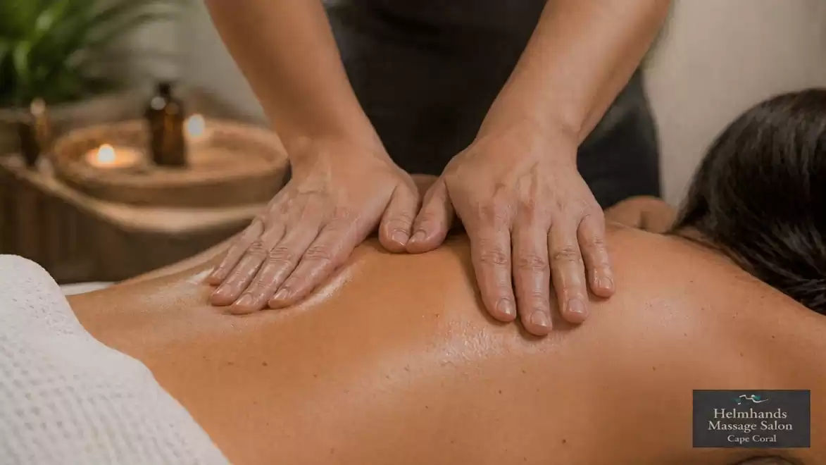 Close-up of a professional massage with hands massaging a person's back in a relaxing atmosphere with candlelight.