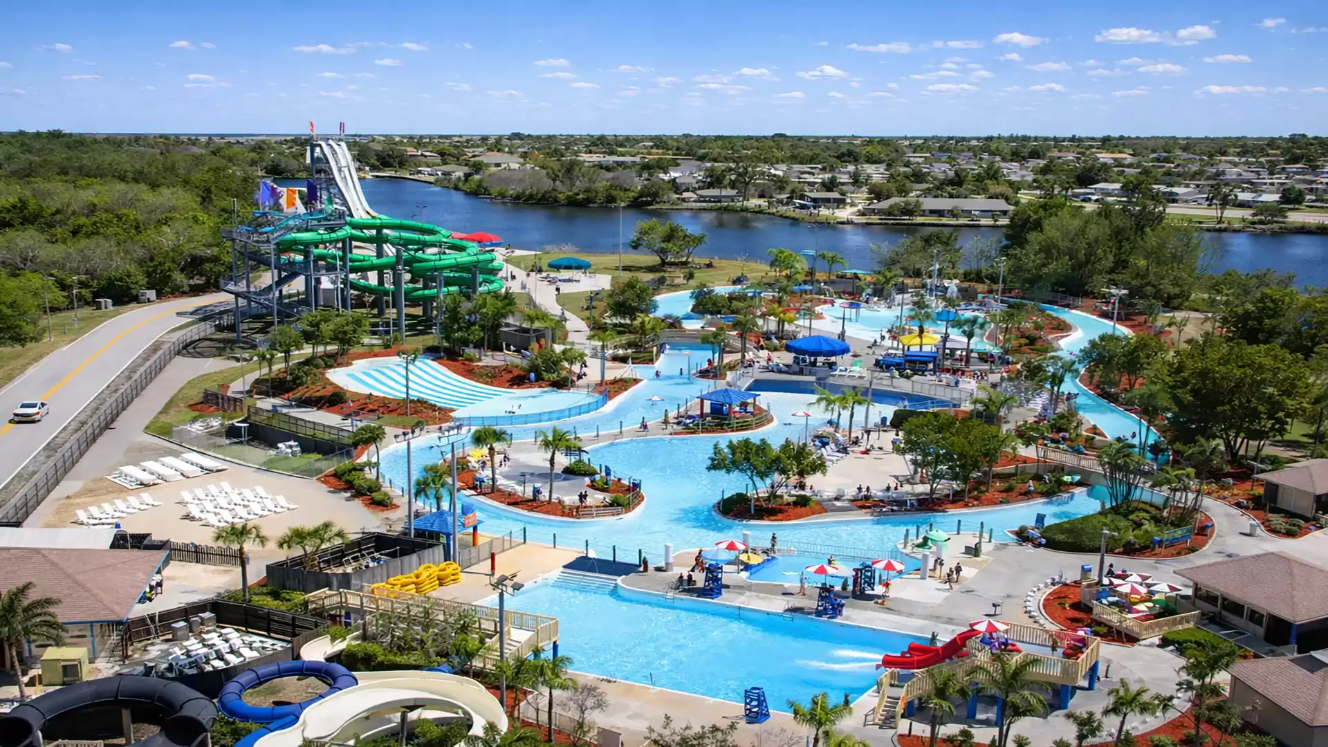 Aerial view of a large water park with colorful water slides, pools, and surrounding nature.