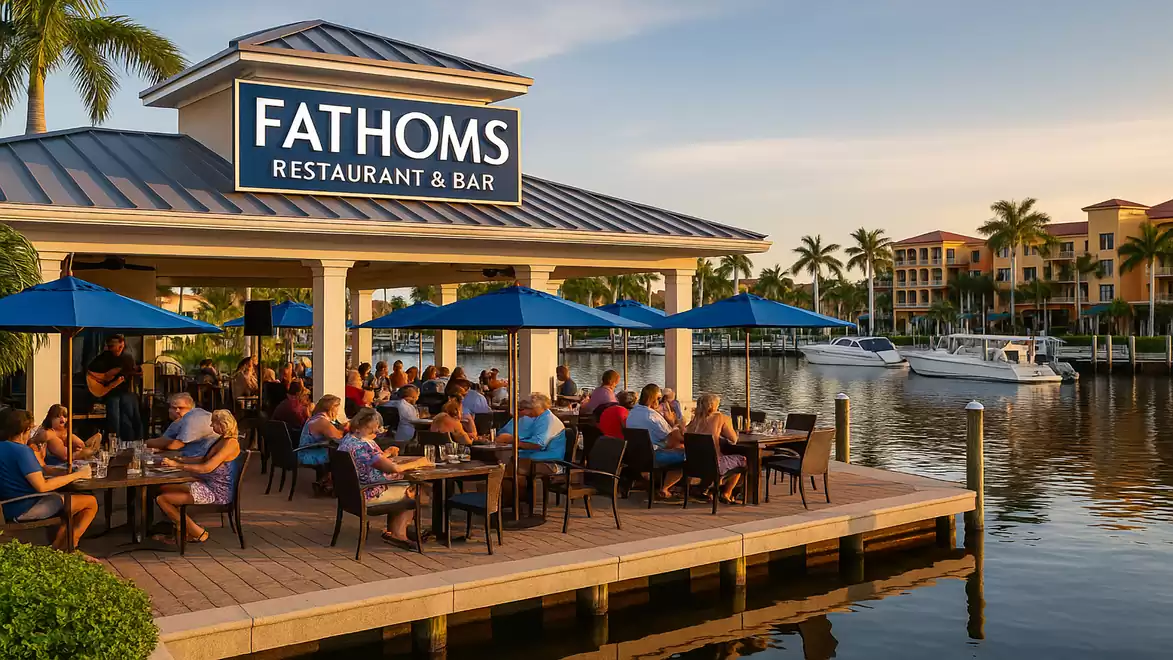 Fathoms Restaurant and Bar at a scenic waterfront, people enjoying meals under umbrellas.
