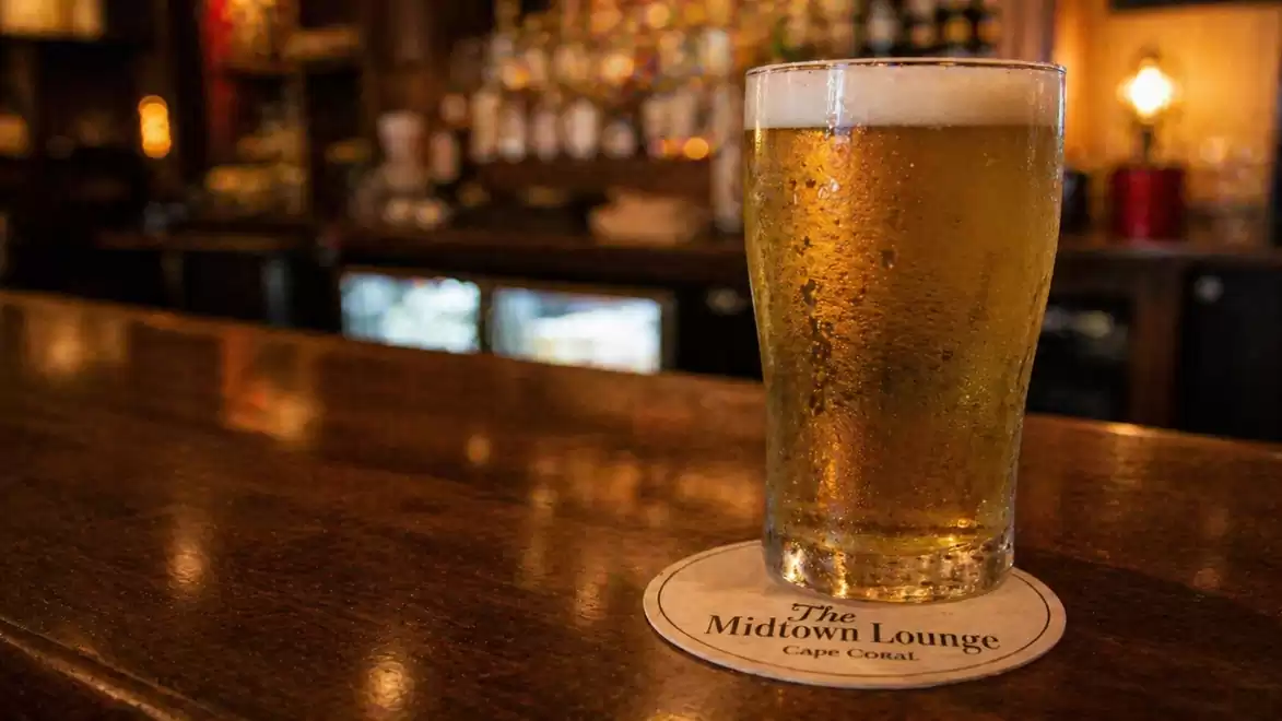 A glass of beer on a bar counter in a cozy pub.