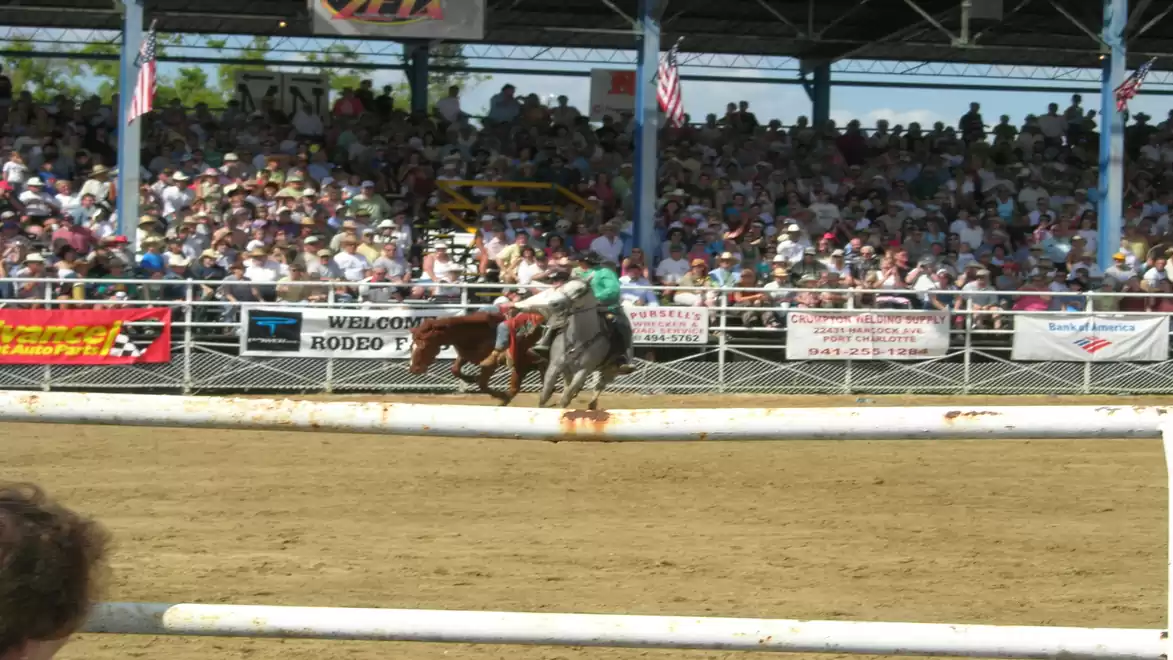 An exciting horse race with two riders in a packed arena.