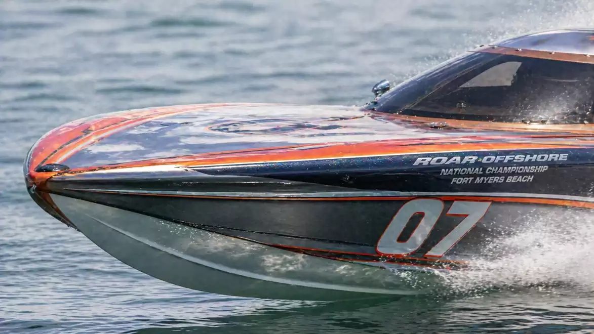 Close-up of a racing boat with number 07 quickly gliding over the water.
