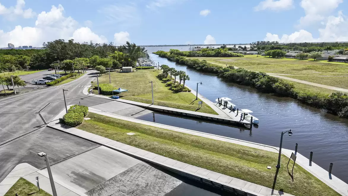 Landscape view of a canal with surrounding greenery and a road in a tranquil setting.
