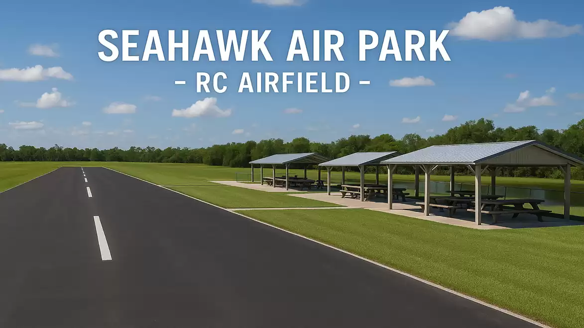 Aerial view of Seahawk Air Park featuring a long, straight runway and covered picnic tables on a well-kept lawn.