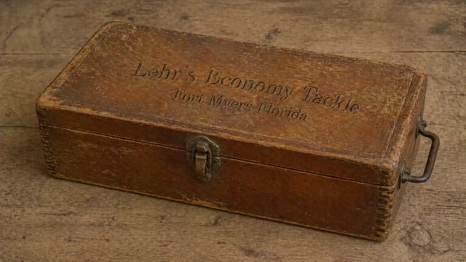 Old wooden box with the inscription 'Lehr's Economy Tackle, Fort Myers, Florida' on a wooden table.