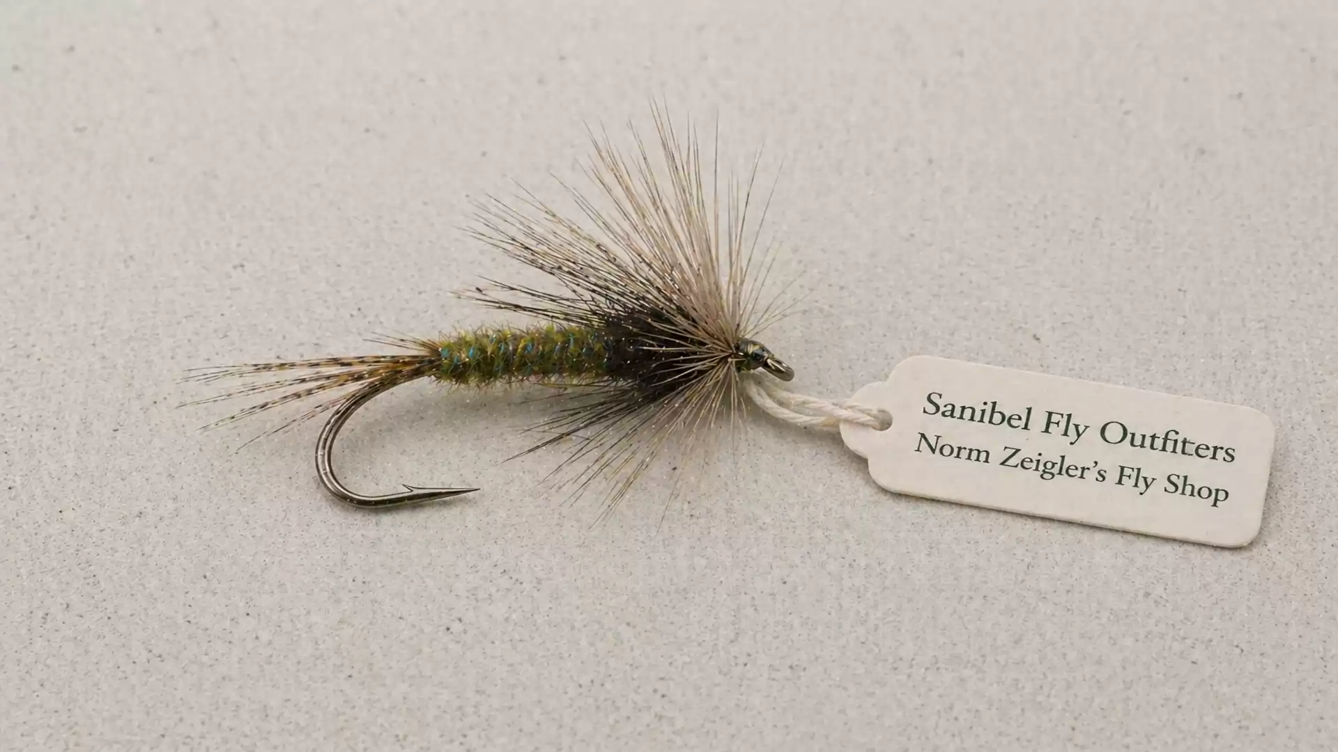 A fly fishing lure with a tag from Sanibel Fly Outfitters, Norm Zeigler's Fly Shop.