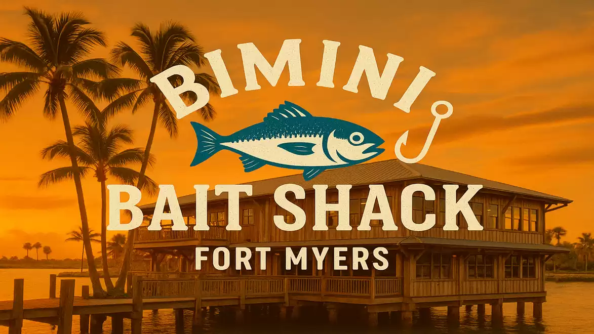 A beach restaurant named Bimini Bait Shack Fort Myers with an orange sunset and palm trees.