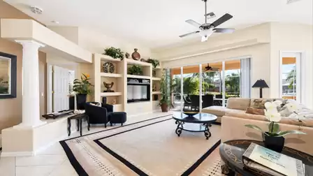 The living room features comfortable sofas and arm chairs as well as a large TV