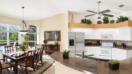 Open-plan living area with views of the kitchen, dining area and pool