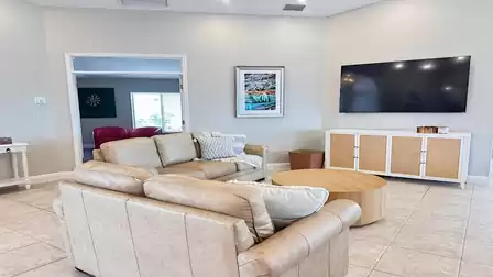Cozy living area with beige leather sofas, large flat-screen TV, and stylish decor