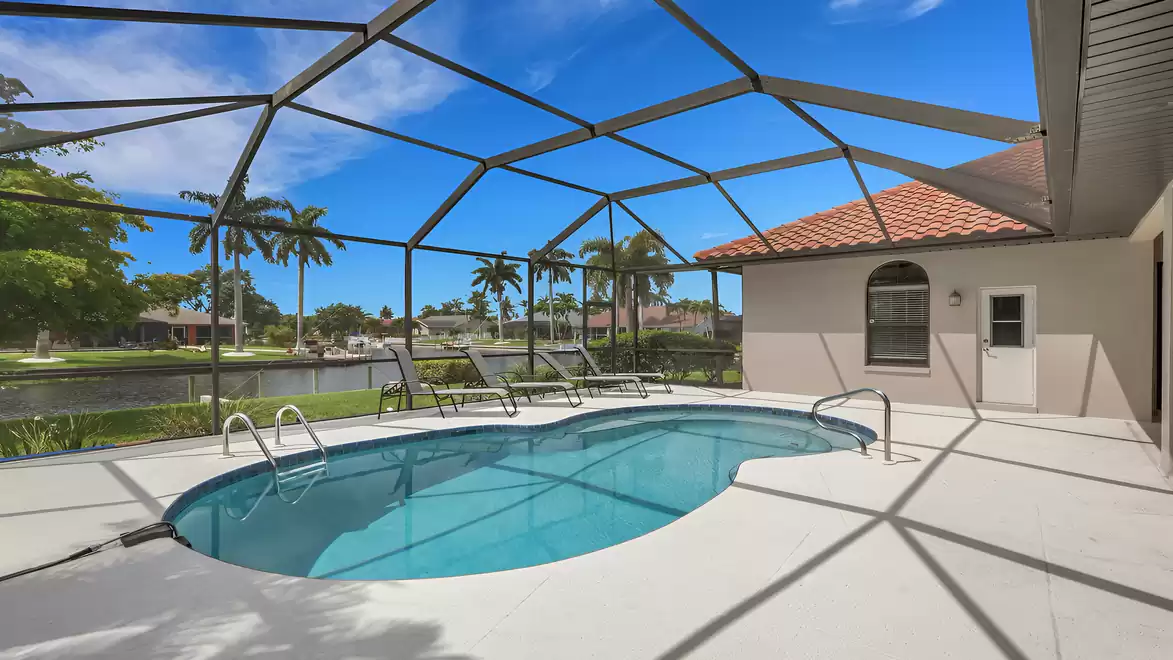 Villa Shakira Cape Coral vacation home screened pool deck with canal view and loungers