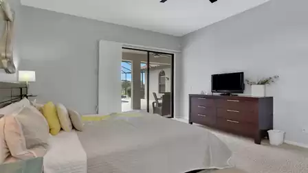 Bedroom with double bed, dark dresser with TV and sliding door to terrace