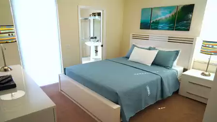 A Queen size bed can be found in the second bedroom