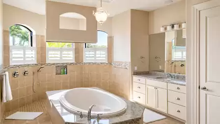 The adjacent master bath impresses with a walk-through shower behind a glass wall