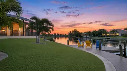 Private dock at a Florida vacation villa with palm trees and canal views at sunset