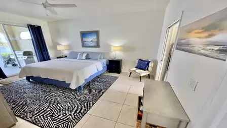 The blue and white master bedroom welcomes you with an king-size bed