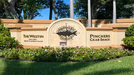 Entrance sign for Tarpon Point Marina between The Westin and Pinchers logos