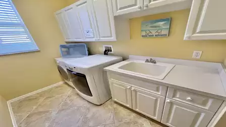 The laundry room includes washer, dryer and sink
