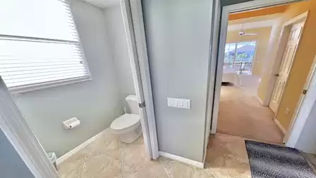 A sliding door separates the toilet from the rest of the bathroom