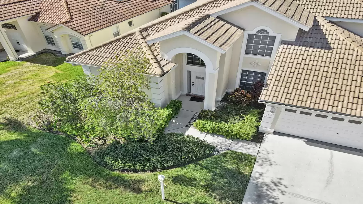 The house is surrounded by a tropical garden