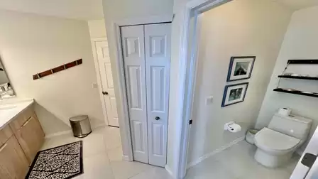 Bathroom with separate toilet area, vanity, storage space and a clean, bright design.