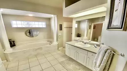 large bathroom with 2 sinks, tub and shower