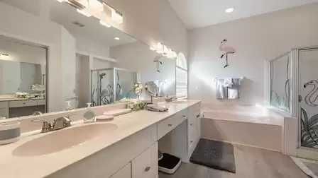 The adjoining bathroom with double sink, shower and tub