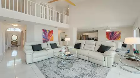 Bright, open living area with comfortable sofas, gallery, modern kitchen and plenty of natural light for relaxed living.
