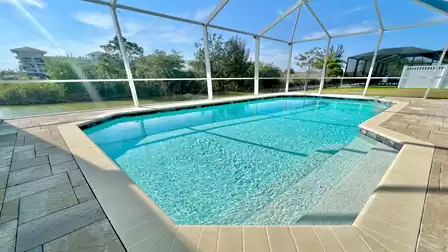 Private pool area with crystal-clear water and canal view.