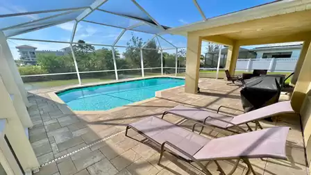 Pool deck with sun loungers and covered dining area.