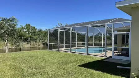 Spacious yard with pool and nature view.
