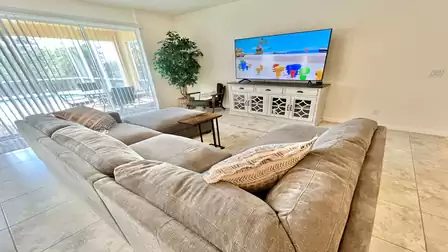Cozy living room with large sofa and TV.