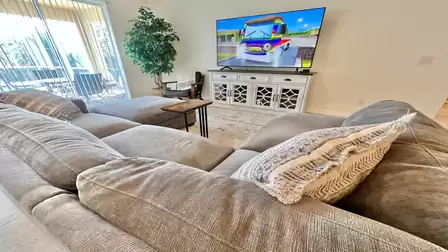 Spacious living area with TV and outdoor view.