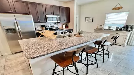 Kitchen island with granite countertop and view of the living area.