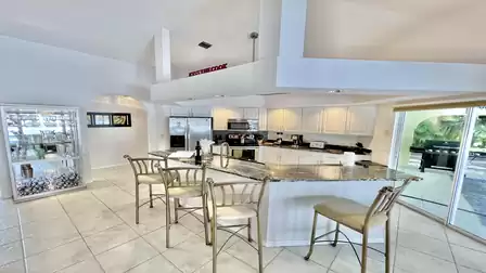 A look inside the white high-gloss kitchen with stainless steel appliances