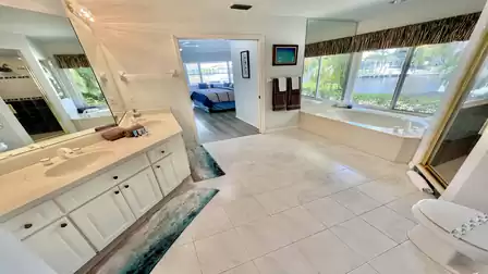 The bathroom with double faucets, walk-in shower and bathtub overlooking the canal