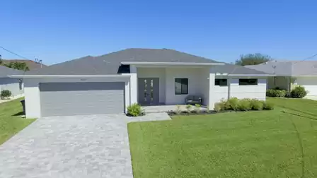 The green grass harmonizes perfectly with the white and grey of the house