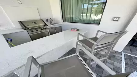 Equipped with a cool cocktail, you can watch the grill master at work here