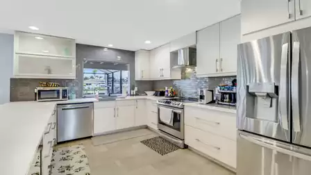Ultra modern kitchen with glossy white furniture and stainless steel appliances