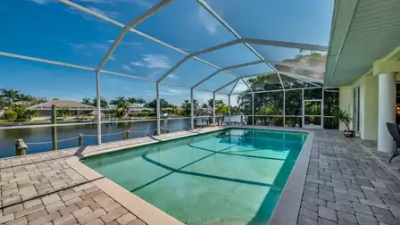 Screened pool area of Villa Donatella with a view of the canal – enjoy relaxing moments by the water in a tropical setting.