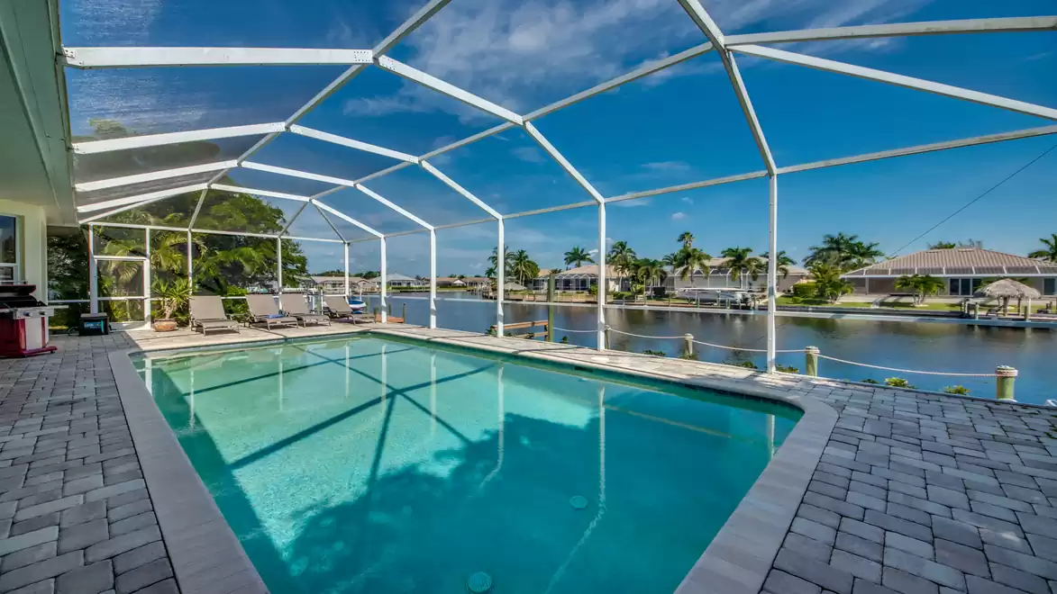 The spacious pool area of Villa Donatella offers a stunning view of the canal and is fully enclosed by a screen.