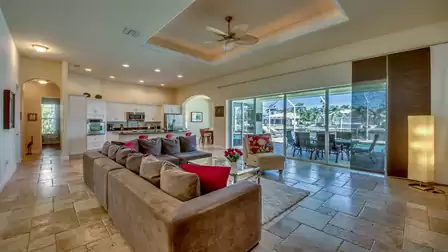 Bright and inviting living room of Villa Donatella with an open kitchen and access to the terrace and pool area.