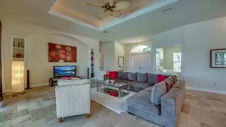 Tastefully furnished living room with a cozy sofa set, modern decorations, and a direct view of the entrance area.