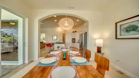 Stylishly furnished dining area with modern lighting and open access to the kitchen and living area.