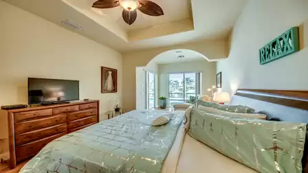 Elegant bedroom with a wooden dresser, wall decor, and a cozy atmosphere for restful nights.